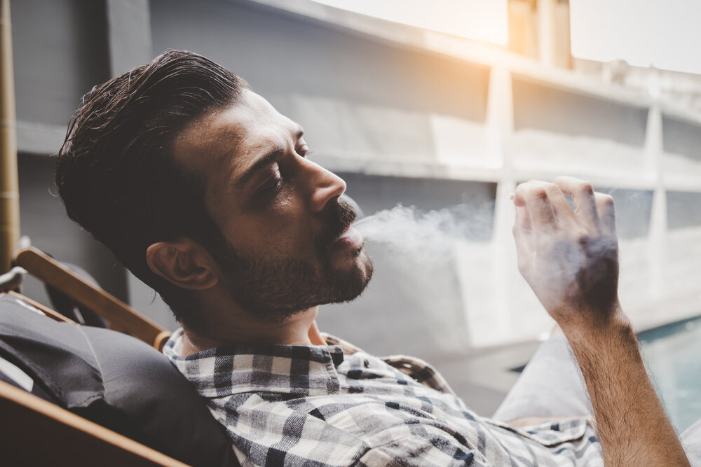 a man smoking a joint looking relaxed