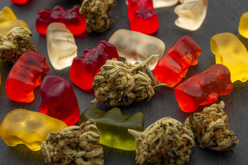 cannabis edibles and bud together on a black table