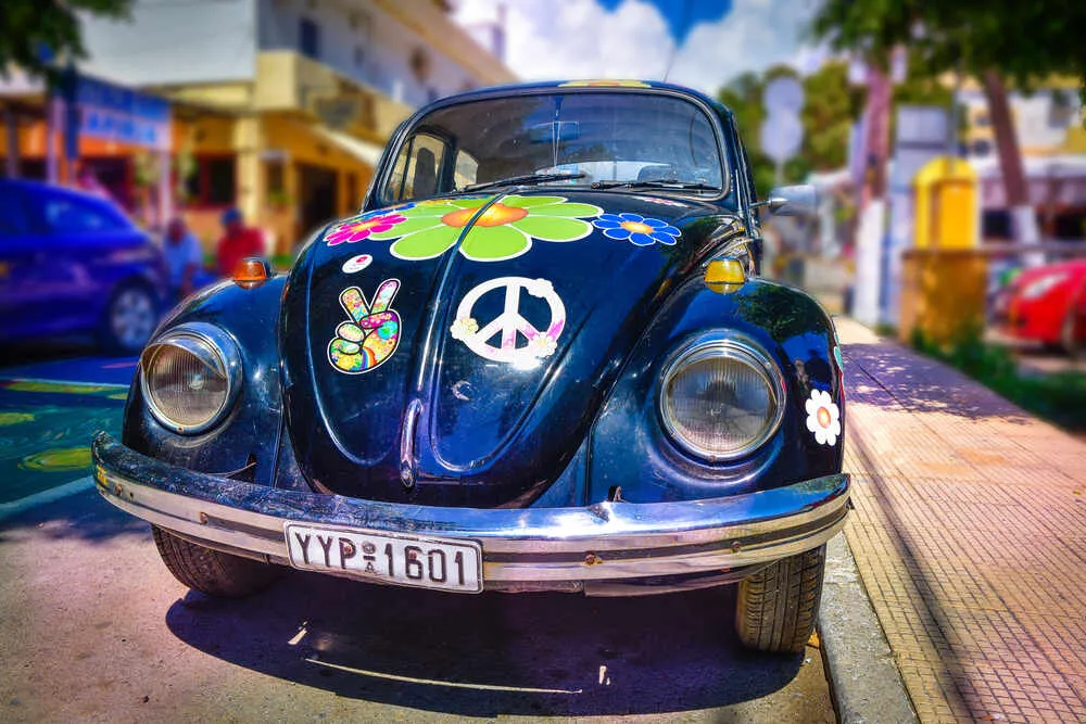 a car with loads of hippie stickers on it